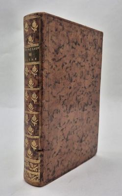 an old book sitting on top of a white table next to a white wall