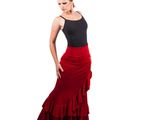 the woman is wearing a red skirt and black top