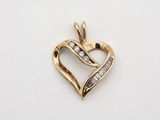 un pendentif en forme de cœur en or serti de diamants sur fond blanc