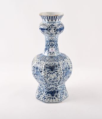 un vase bleu et blanc posé sur une surface blanche