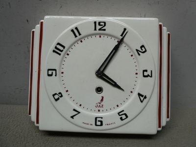 une horloge blanche avec des chiffres noirs, posée sur une table