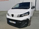 l'avant d'une camionnette blanche garée devant un immeuble