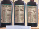 three bottles of alcohol on a shelf with a price tag