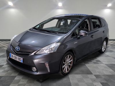 La Toyota Prius grise est garée dans une pièce dont le sol est à carreaux.