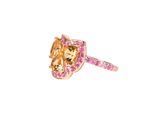 a close up of a ring with a horse and pink sapphires