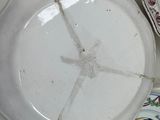 a white plate with a crack in it sitting on a table