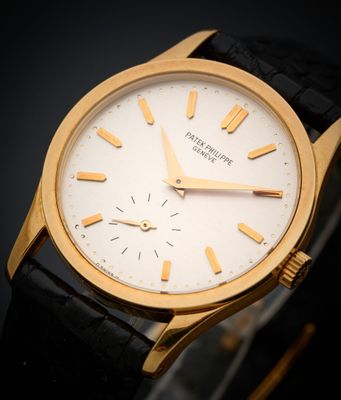 gros plan d'une montre-bracelet en or sur une surface noire