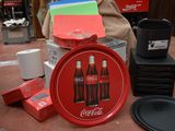 un plateau rouge sur lequel se trouve un Coca-Cola, à côté d'autres objets