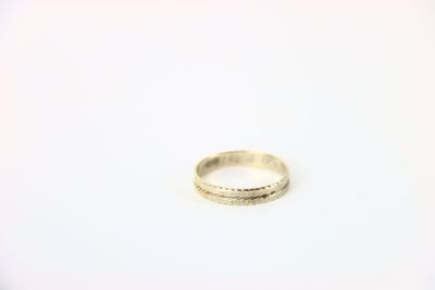 gros plan d'une bague en argent sur une surface blanche