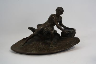 bronze figurine of a woman sitting on a boat with a dog