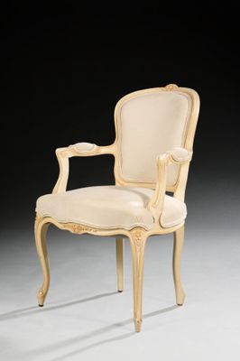 a white chair with a beige upholstered back and arms