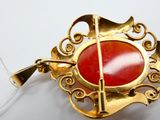 une image représentant une broche ornée d'une pierre rouge