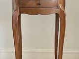 a small table with a drawer on it and a lamp on it