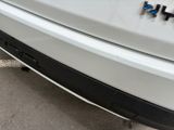 a close up of a white car with a blue emblem on it