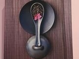une photo d'une cuillère ornée d'une fleur