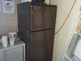 a refrigerator and microwave in a small room with a ladder