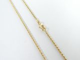 a gold plated necklace with a chain that has been set on a white surface