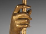 an image of a gold statue of a hand holding a pole