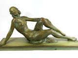 bronze statue of a woman sitting on a base with her legs crossed