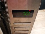 a clock on the side of a microwave on a wooden table