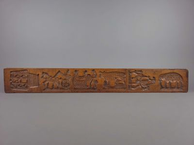 une plaque en bois sculpté représentant une scène où l'on voit un homme et une femme dans un bateau