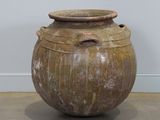 un grand vase posé par terre dans une pièce
