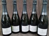 six bouteilles de vin sont alignées sur une table