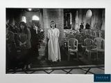 a black and white photo of a woman standing in a church