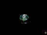 a close up of a green diamond on a black surface
