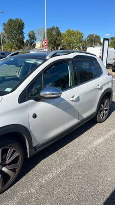 La voiture blanche est garée sur le bord de la route, dans le parking.