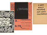 Trois livres sont alignés sur une surface blanche ; l'un d'eux a une couverture noire et orange.