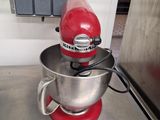 un mixeur rouge posé sur le plan de travail de la cuisine