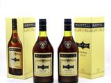 three bottles of martelli brandy and a box of wine on a table