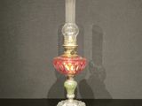 une lampe en verre ornée d'un motif rouge et vert