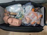 une valise remplie d'objets posée par terre