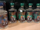 six bouteilles d'alcool sont alignées sur une table