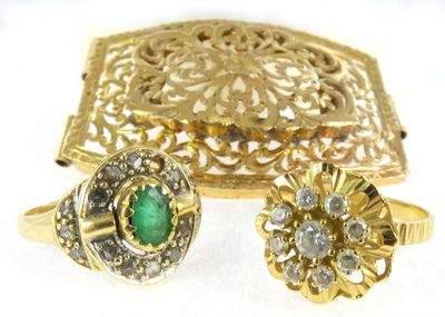 two gold rings and a ring with a green stone in it