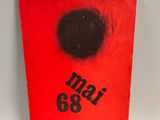 a red book with a black dot on the cover