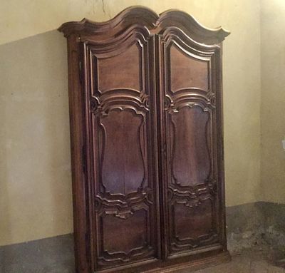 une grande armoire en bois dans un coin d'une pièce