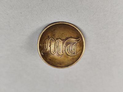 une petite pièce d'or sur laquelle est inscrit le mot « espoir »