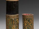 two black and green vases sitting next to each other on a gray surface