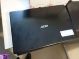 a black laptop sitting on a table with a purple flower