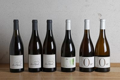 six bottles of wine are lined up in a row on a table