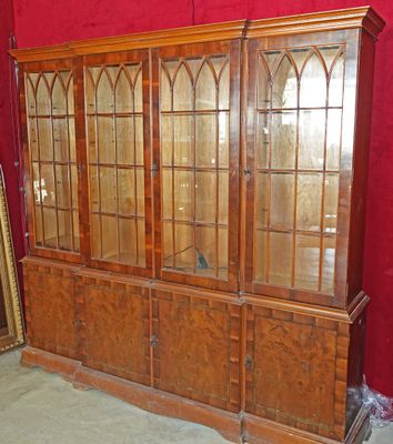 une armoire en bois avec des portes vitrées et un miroir accroché au mur