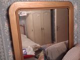 a mirror that is sitting on a dresser in a room