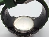 a close up of a wrist watch with a green strap