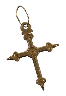 croix en métal plaqué or, au motif ouvragé, sur fond blanc