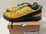 a close up of a pair of yellow and black shoes on a box