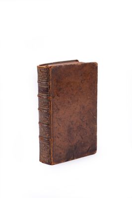 an old book is sitting on a white surface with a white background