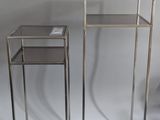 pair of silver metal nesting tables with glass tops